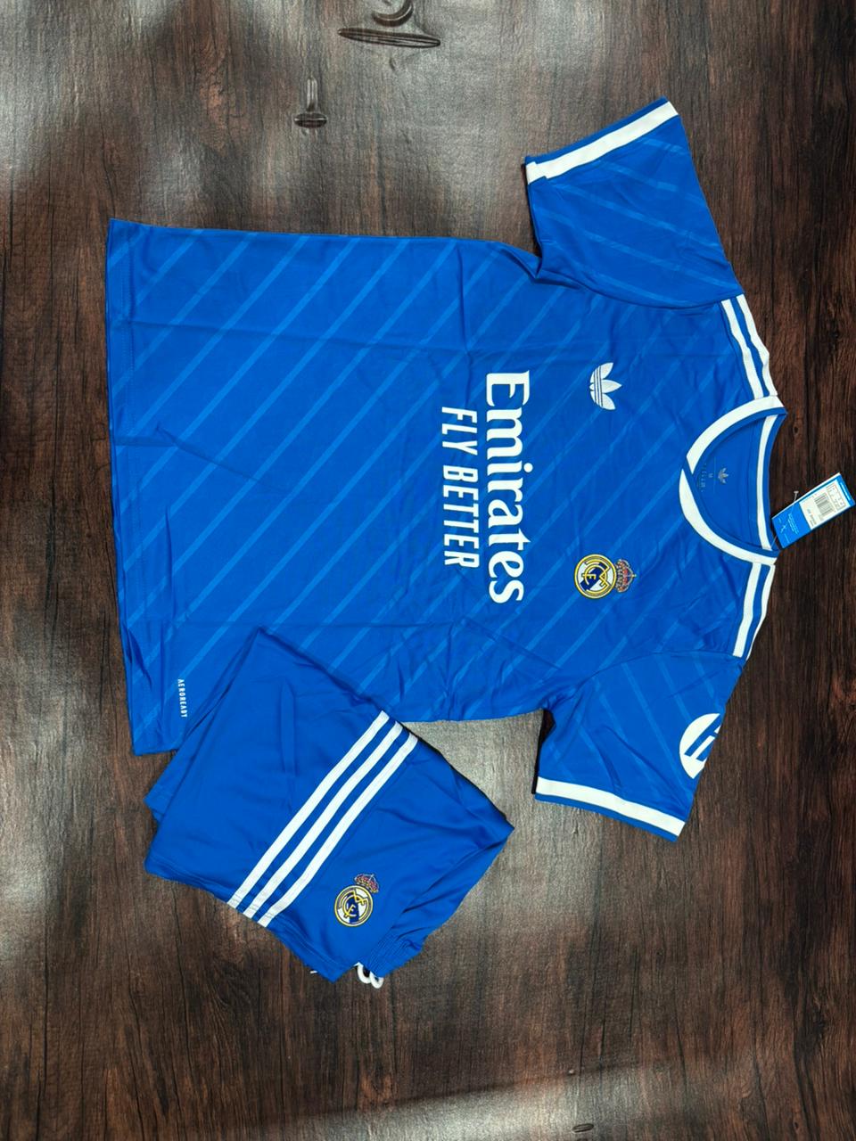 Blue sports jersey and shorts with visible branding on a wooden surface